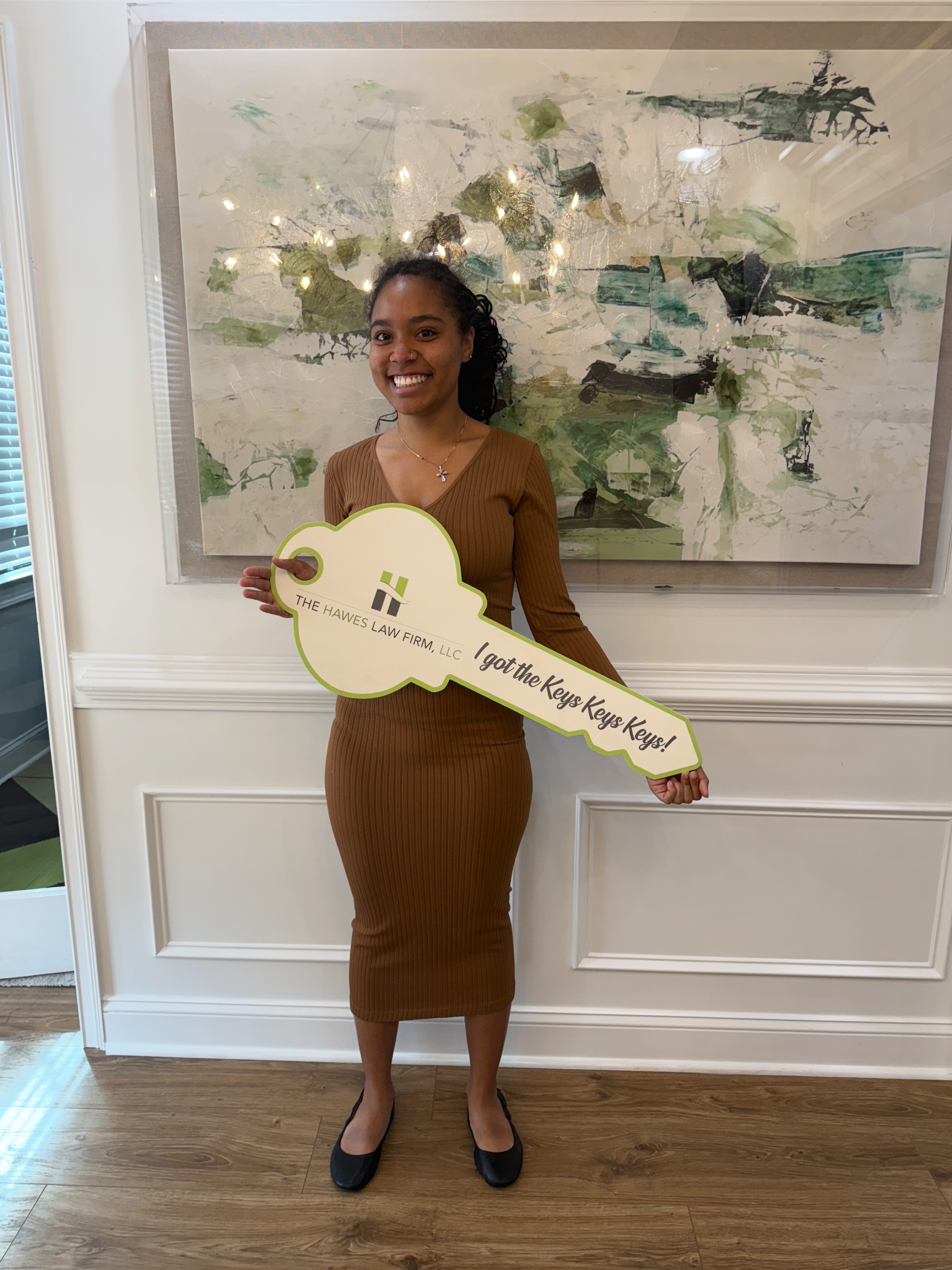 A new homebuyer holding the I Got the Keys! sign — guided through the purchase by Jacqueline Walker.